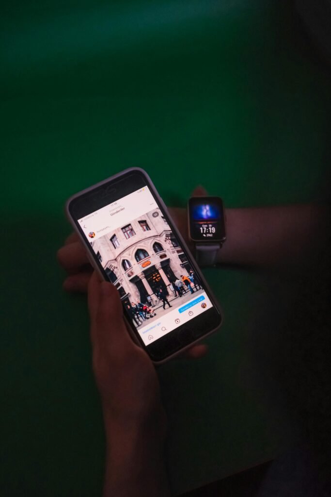 Pessoa com smartwatch e celular nas mãos, representando funções pouco conhecidas do smartwatch como pagamentos por aproximação via NFC.