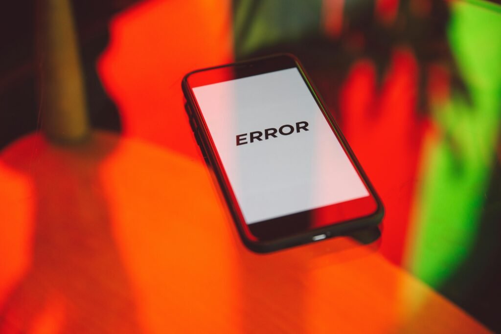 Mão segurando smartphone com alerta de bateria mostrando celular esquentando e descarregando rápido em superfície de madeira