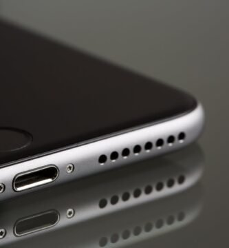 Como limpar o alto-falante do celular que está com som baixo - smartphone sobre mesa com grade do speaker visível